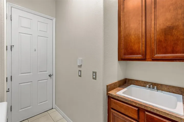 A convenient Laundry Room nearby features cabinetry, a vanity with sink and included washer and dryer.