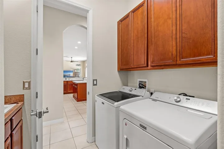 A convenient Laundry Room nearby features cabinetry, a vanity with sink and included washer and dryer.