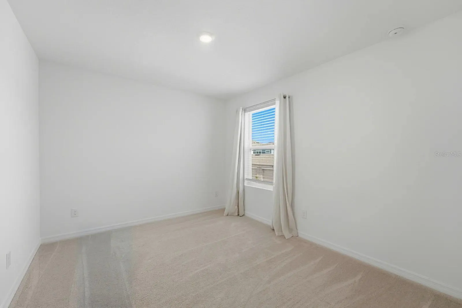 Second upstairs bedroom with neutral carpeting and natural light