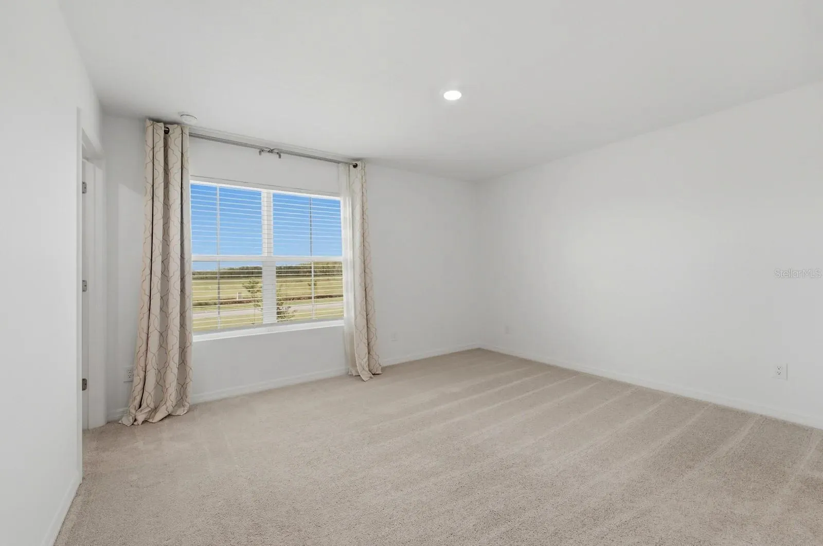 Primary bedroom with carpet flooring and natural light