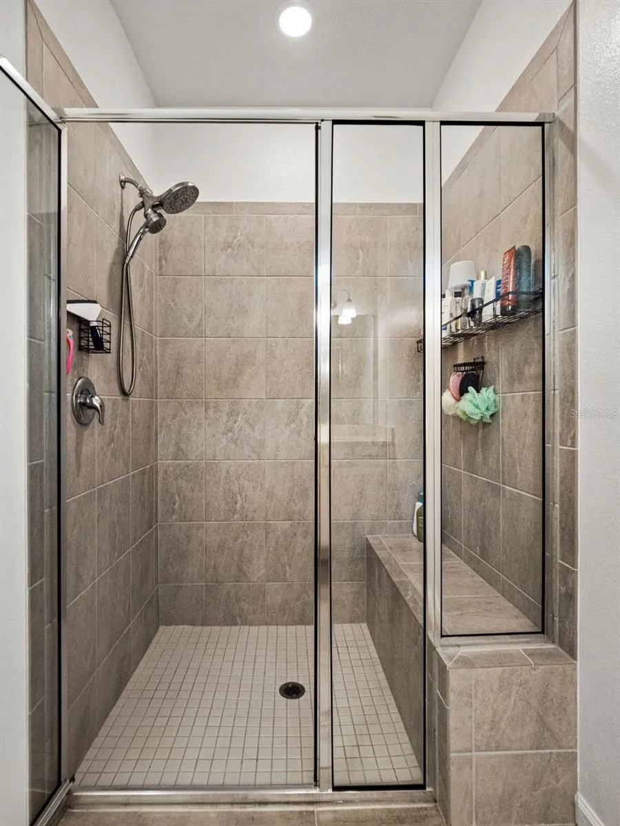 Large walk in shower with built in bench.