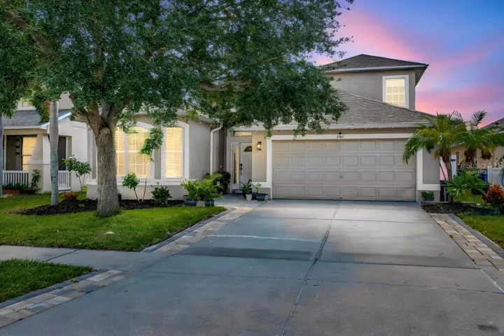 Beautiful Curb Appeal featuring an extended driveway with pavers, sealed and painted pathway and New, Upgraded Front Door. (Virtually Staged Twilight)