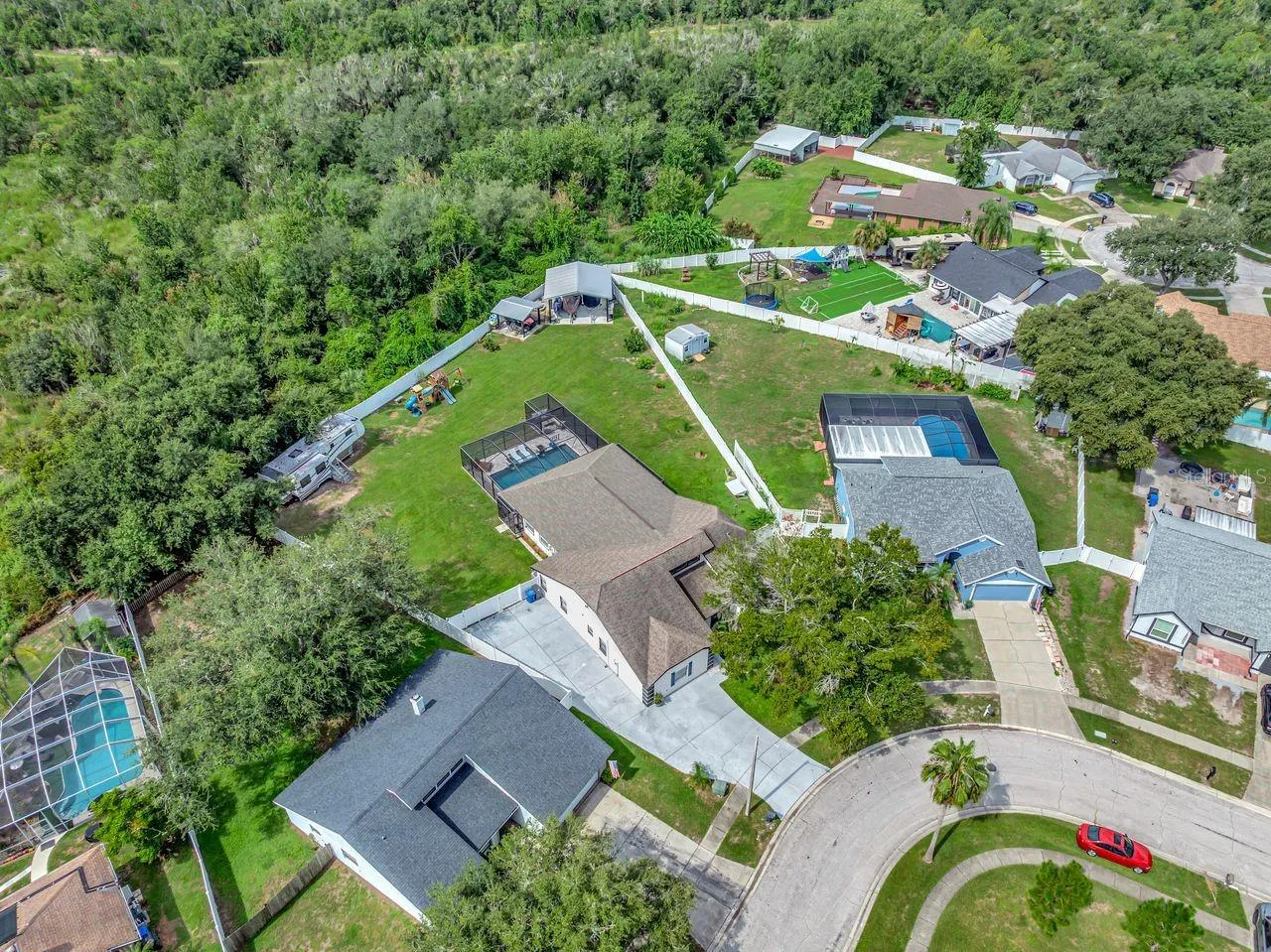 View of Backyard, Playground, Two Covered Open-Air Structured Storage areas with Concrete Pads, Firepit, and Shed. Bring the Boat- Bring the Toys - There's room for everything! No REAR Neighbors; NO CDD; and an optional HOA!