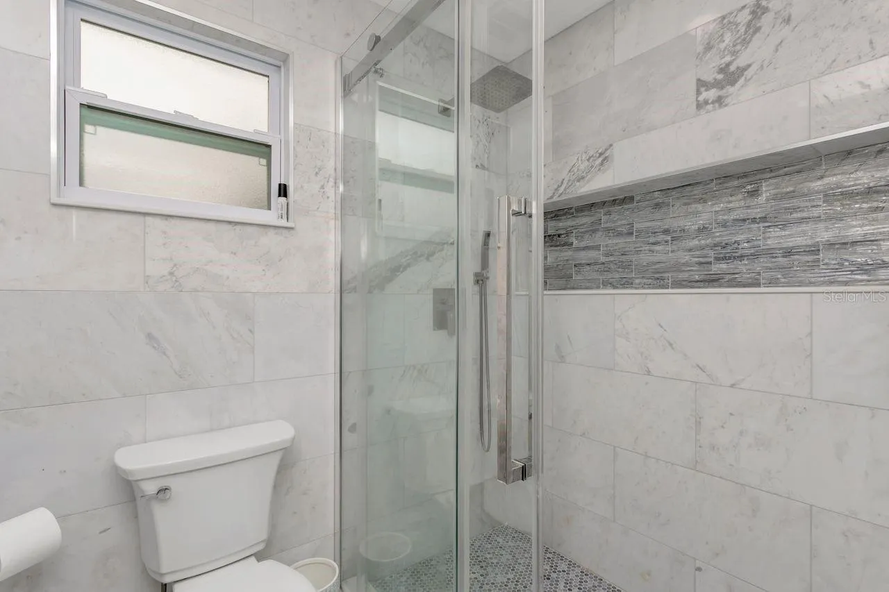 Remodeled Full "Pool Side" Bathroom with elevated fixtures, Shower with Tile to Ceiling and Recessed Decorative Niche; Located off the Kitchen