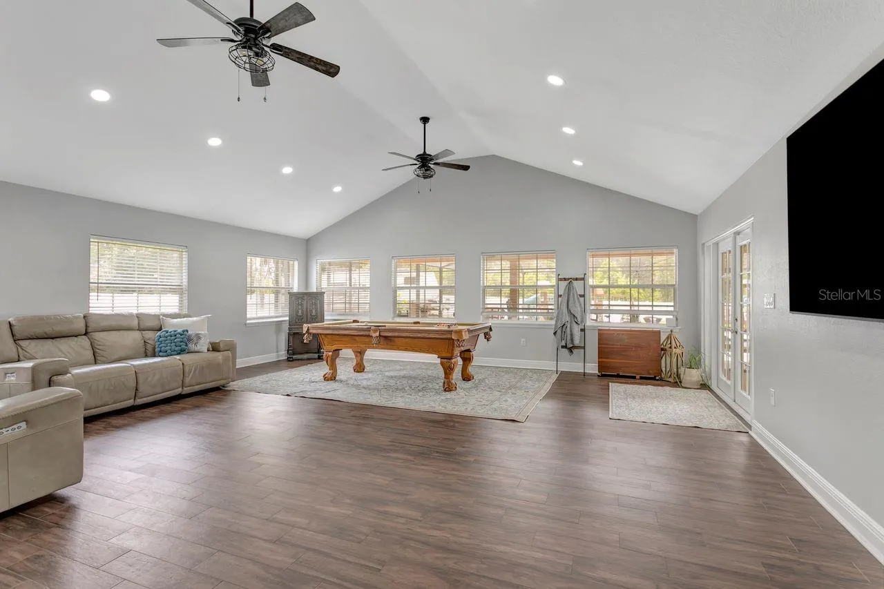 Great Room with Vaulted Ceilings, LVP Flooring, Dual Fans, Recessed Lighting; Tons of Windows, Natural Light, French Doors to your Patio & Covered Lanai