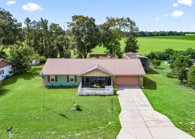 Charming front exterior featuring a classic white picket fence, attractive stone accents, and well-maintained landscaping that create inviting curb appeal.