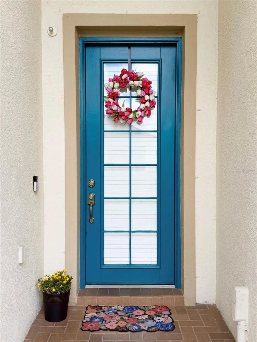 Beautiful brick-pavered entryway with a glass door.