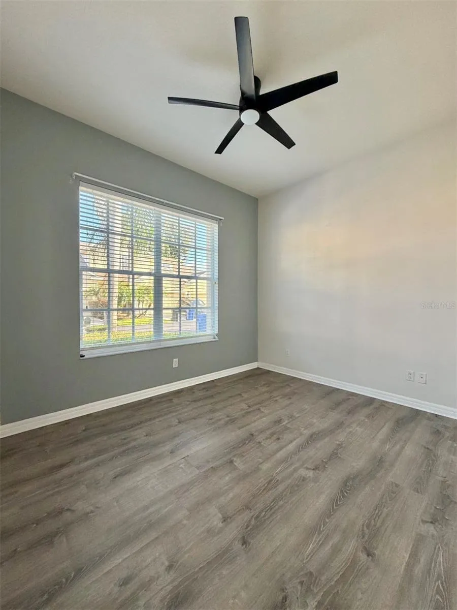 Bedroom 2 faces the front of the home, and it features LVP flooring, a ceiling fan, and an extra-wide closet.