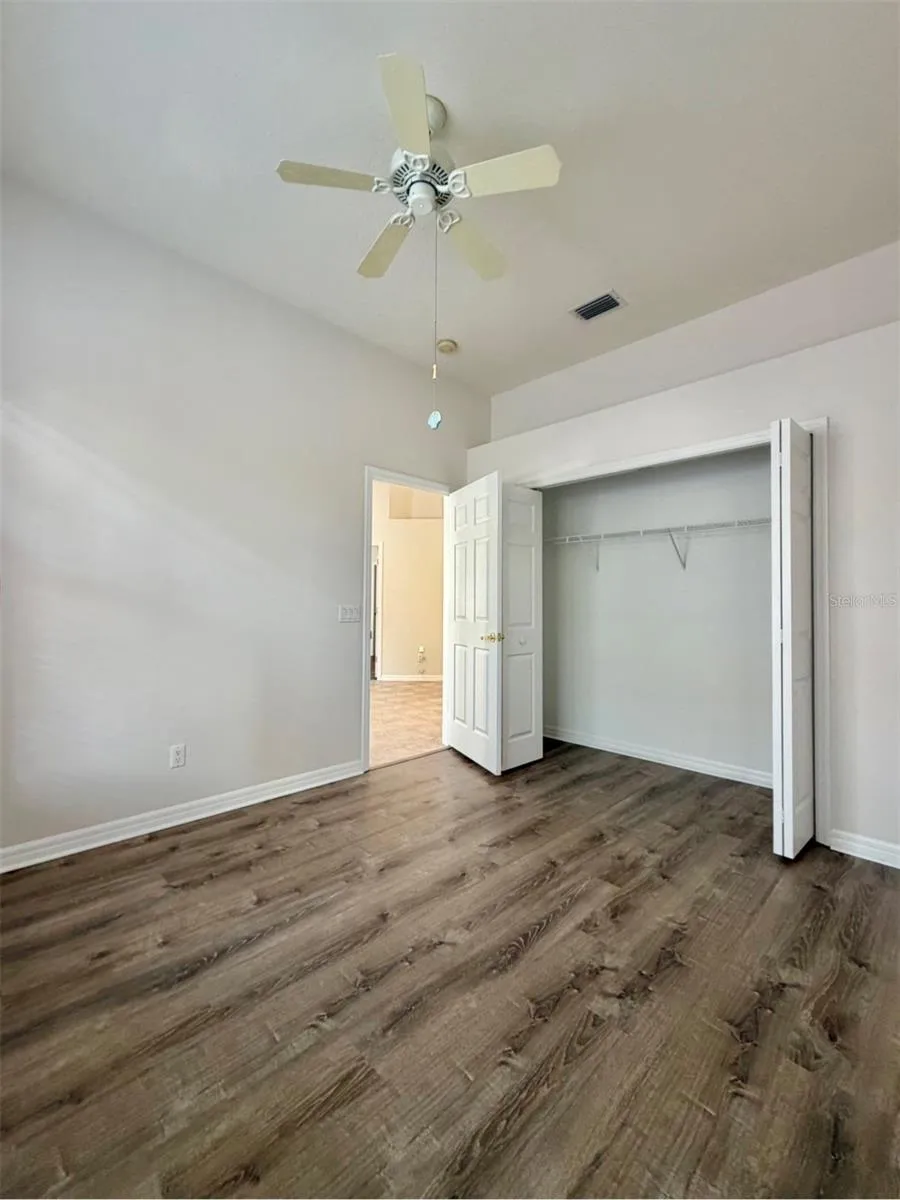 Bedroom 3 overlooks the back patio and features a ceiling fan and an extra-wide closet.