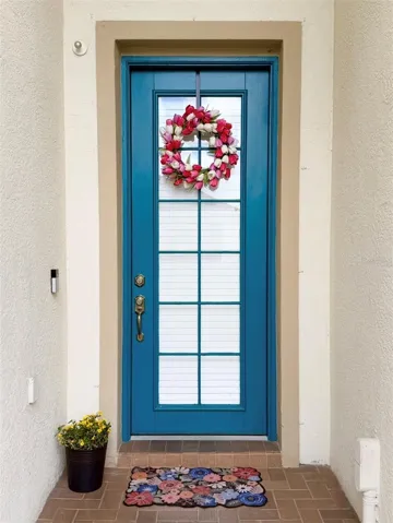 Beautiful brick-pavered entryway with a glass door.
