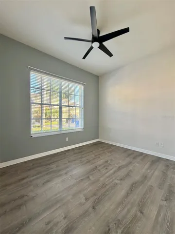 Bedroom 2 faces the front of the home, and it features LVP flooring, a ceiling fan, and an extra-wide closet.