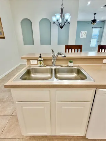 The sink has a new faucet and also a garbage disposal.
