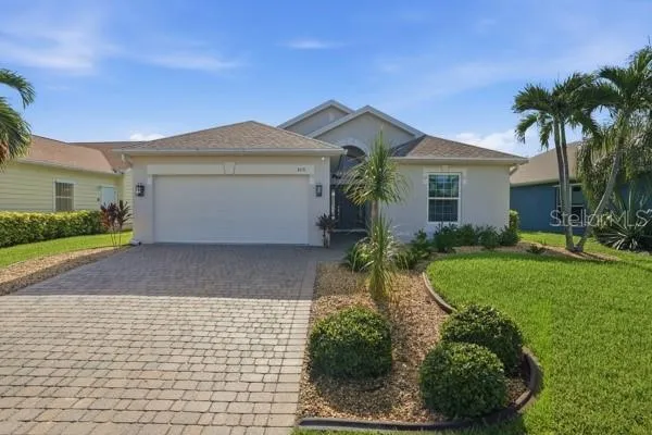 The driveway of this lovely lake front home is lined with beautiful pavers and manicured landscape