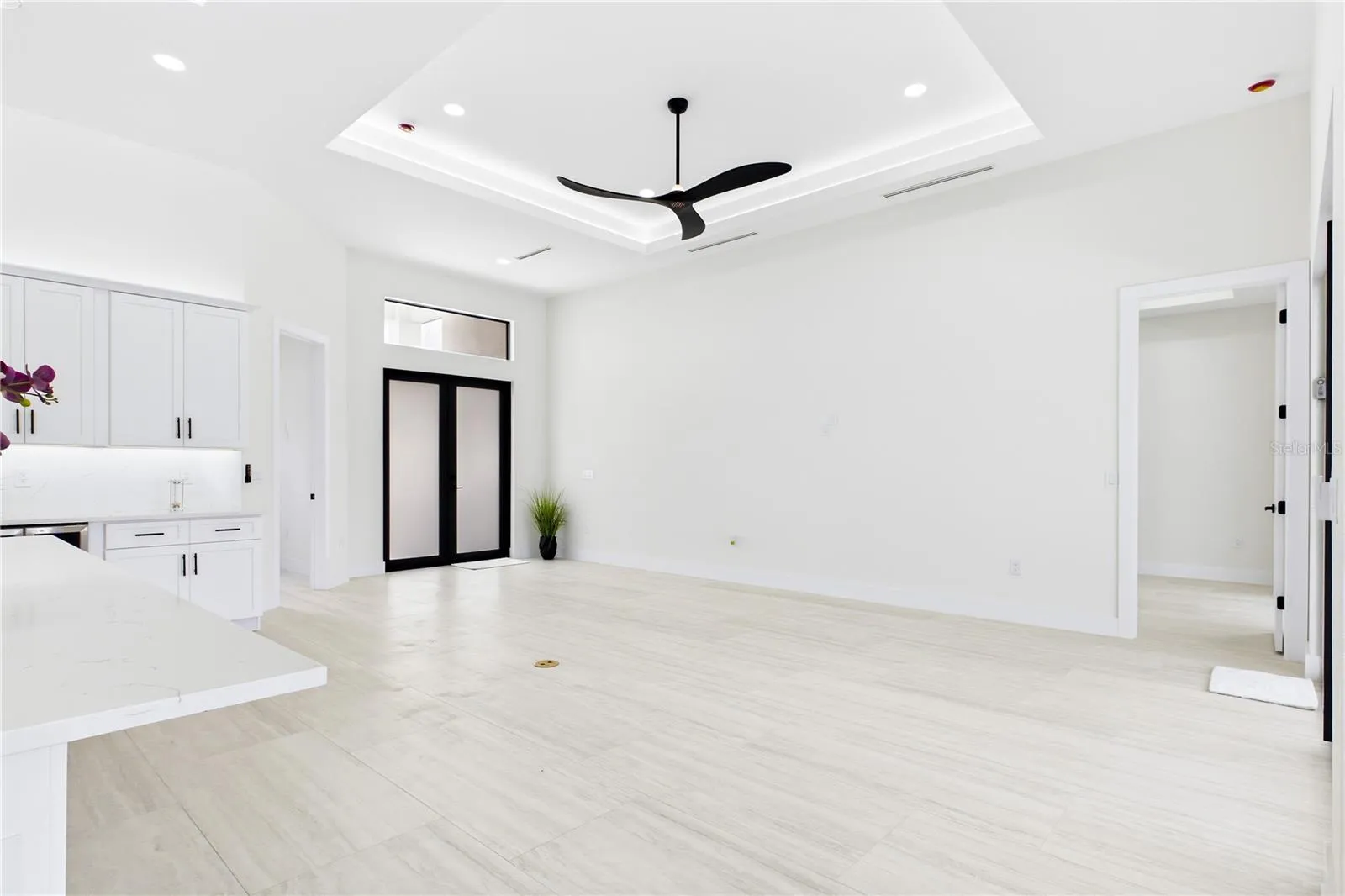 OPEN LIVING AREA showcases a dramatic DOUBLE-TRAY CEILING w/ LED ACCENT LIGHTING, sleek LINEAR A/C DIFFUSERS &amp; contemporary statement ceiling fan.