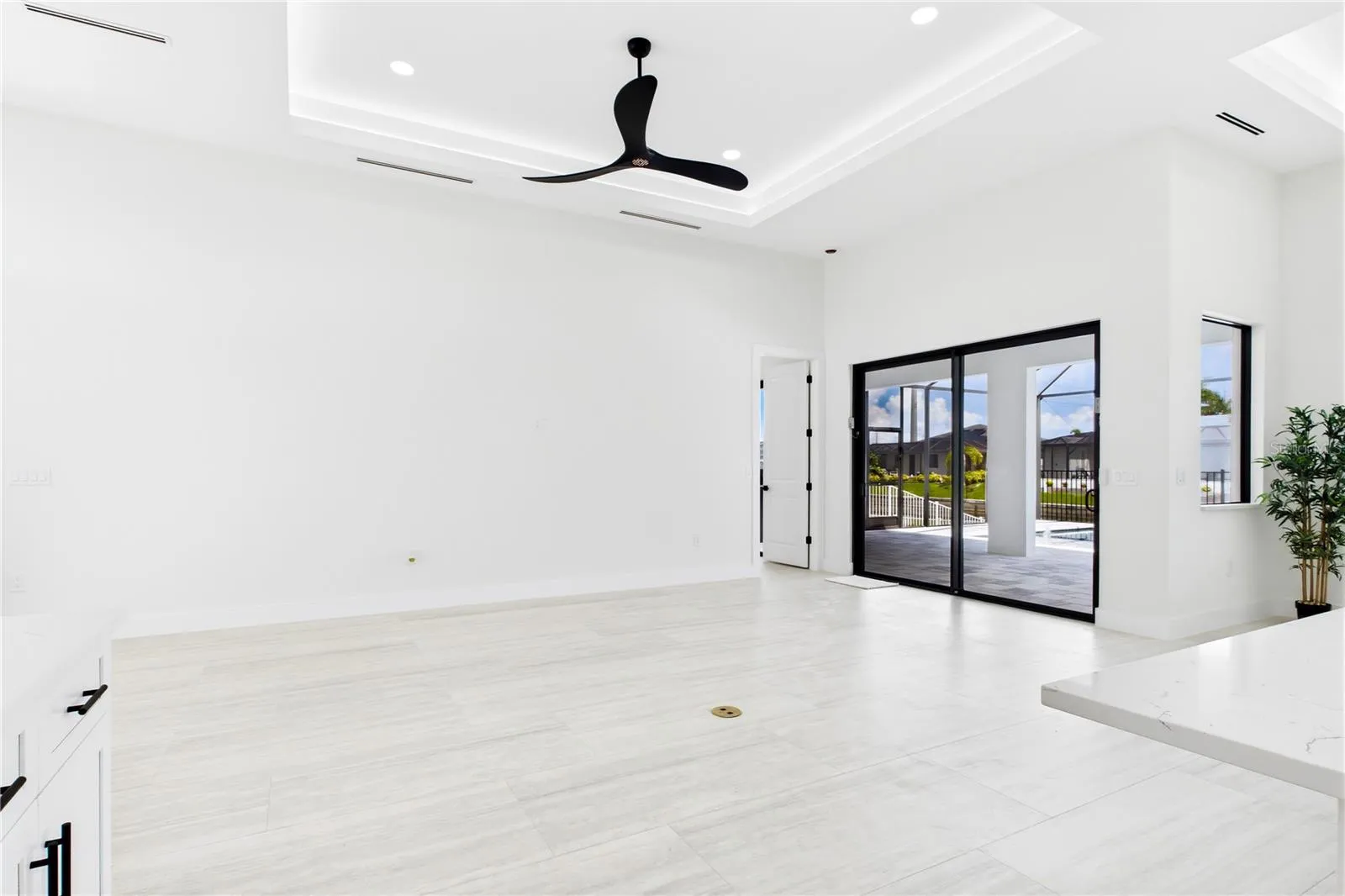 BRIGHT OPEN LIVING AREA w/ soaring VOLUME CEILINGS, dramatic LED-LIT TRAY DETAIL &amp; OVERSIZED SLIDING GLASS DOORS seamlessly connecting to POOL &amp; LANAI.