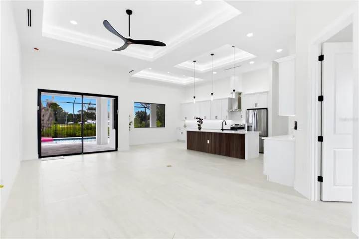 IMPACT-RESISTANT DOUBLE DOORS lead into WELCOMING LIVING ROOM w/ 14-ft VOLUME CEILING &amp; SLIDING DOORS TO LANAI.