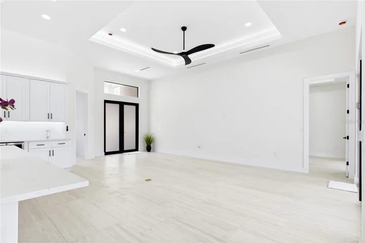 OPEN LIVING AREA showcases a dramatic DOUBLE-TRAY CEILING w/ LED ACCENT LIGHTING, sleek LINEAR A/C DIFFUSERS &amp; contemporary statement ceiling fan.
