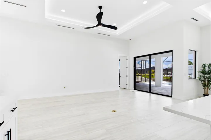 BRIGHT OPEN LIVING AREA w/ soaring VOLUME CEILINGS, dramatic LED-LIT TRAY DETAIL &amp; OVERSIZED SLIDING GLASS DOORS seamlessly connecting to POOL &amp; LANAI.