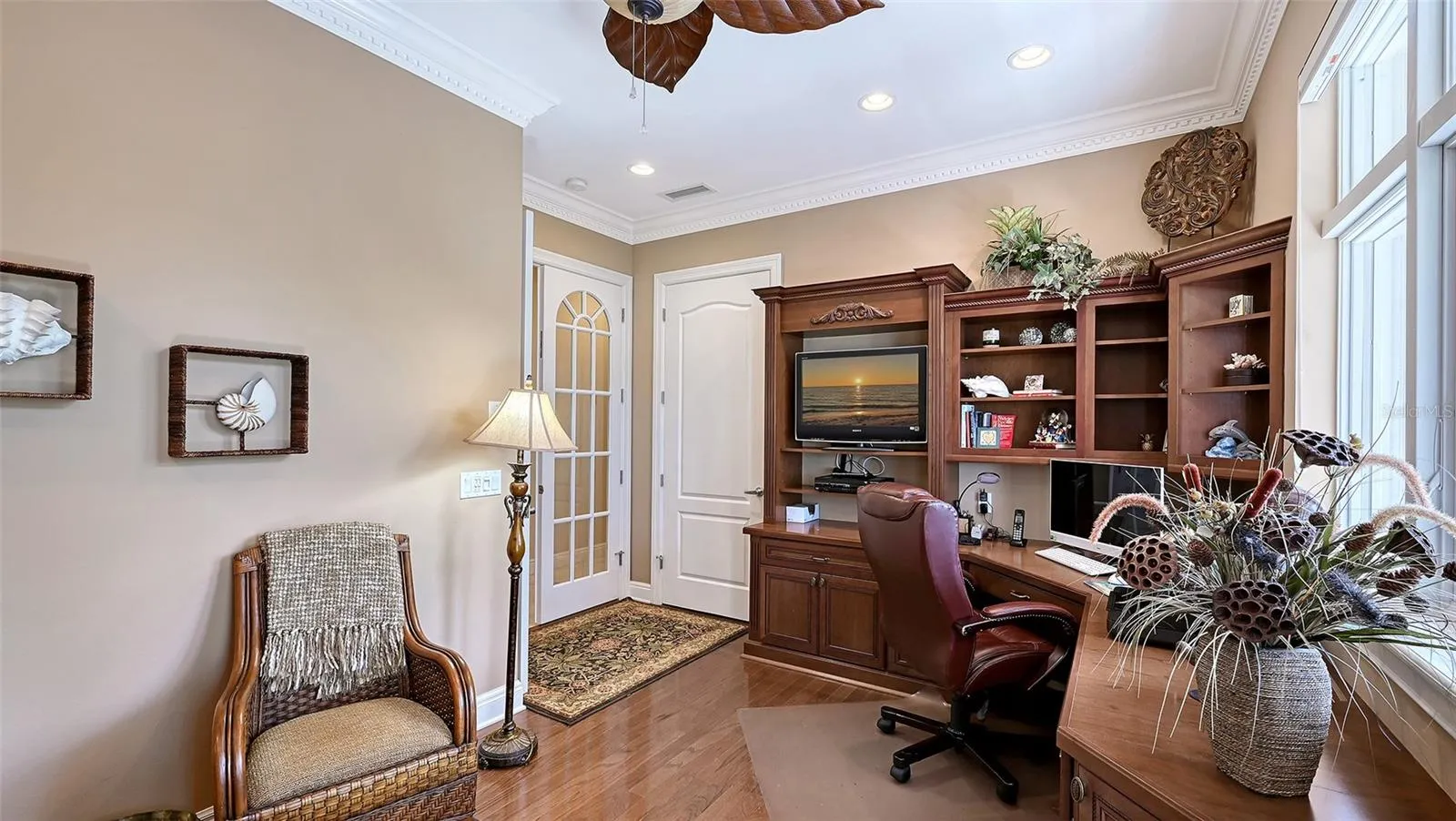 Partial view of current home office with build in cabinetry and private balcony.