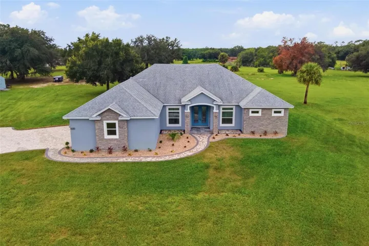 Exterior front of home. Situated on Just under 5 acres of land, brick paver drive, and heated salt water screen enclosed swimming pool.