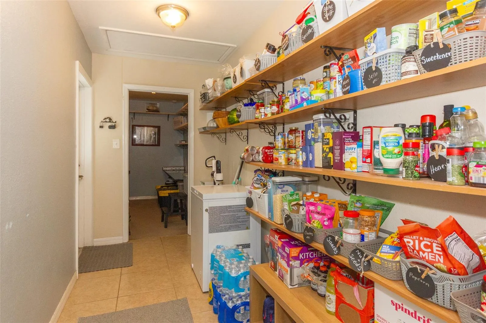 Gigantic pantry with additional storage room beyond, door to left leads outside