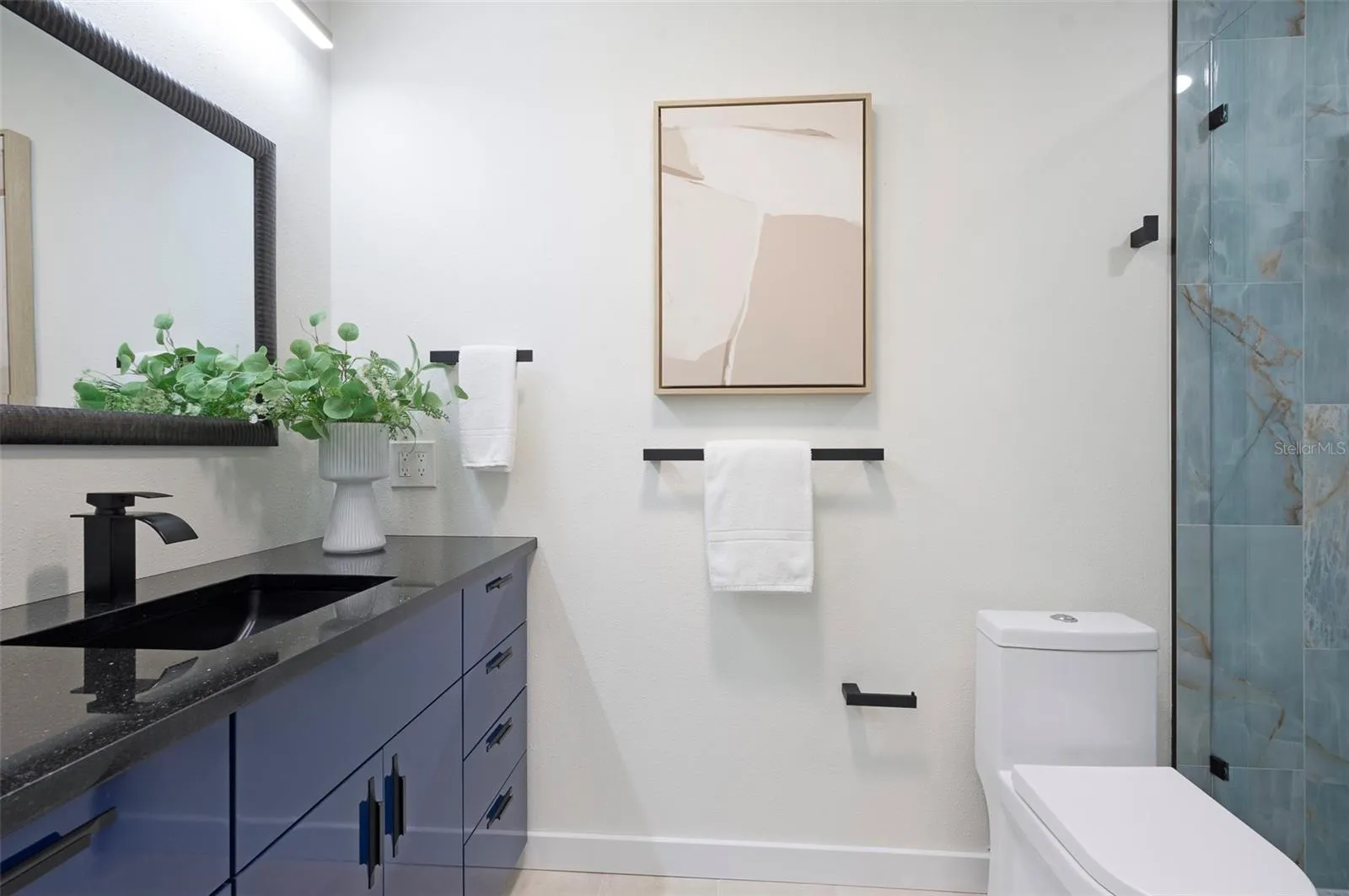The Primary bathroom is functional and features designer touches. A tube skylight brings in natural light.