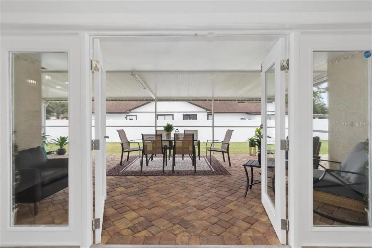 The French doors invite you to a fully enclosed paver patio, offering a versatile space for entertaining, dining, or simply enjoying the Florida lifestyle.