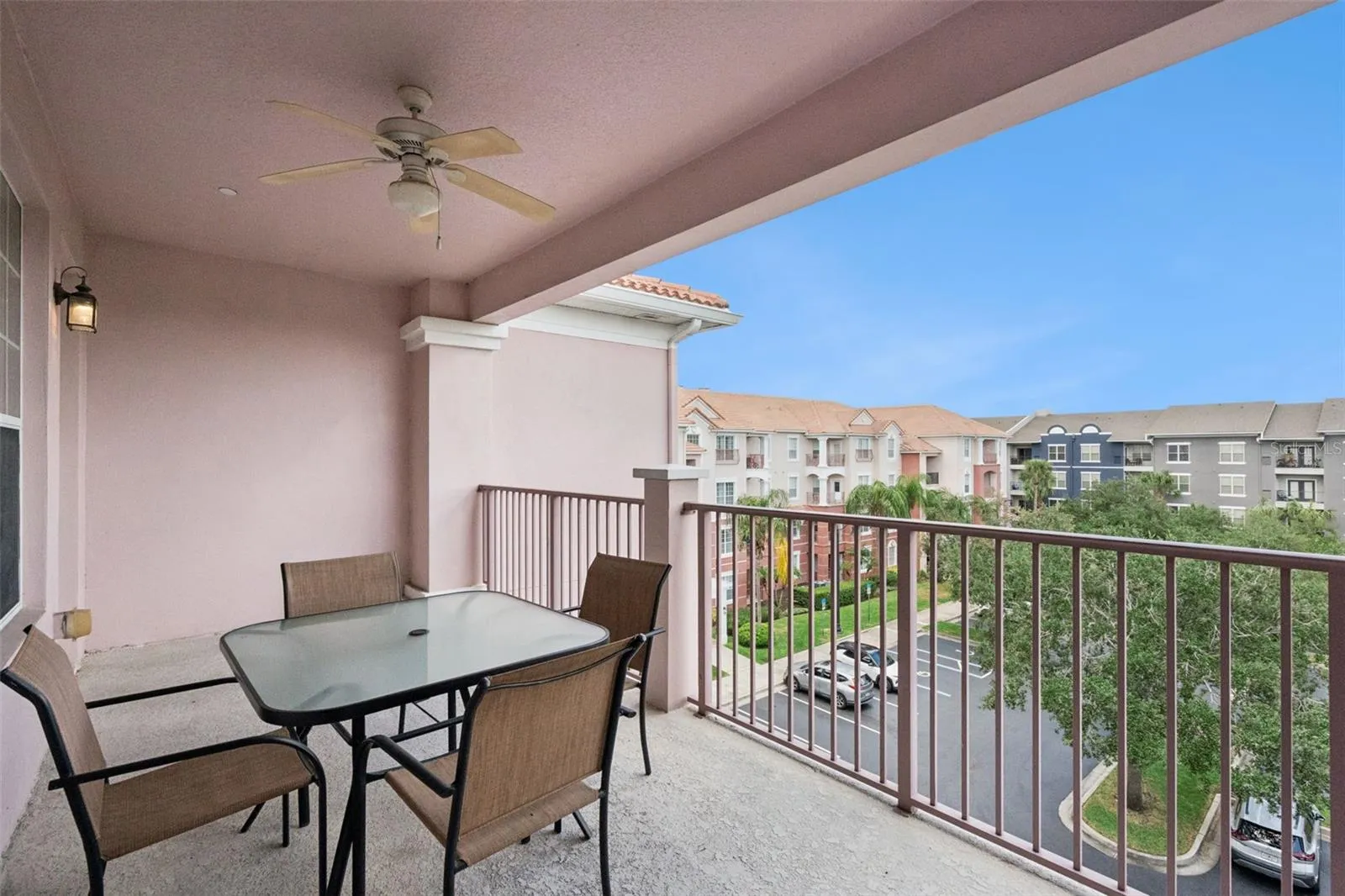 Covered Balcony Overview:Generously sized covered balcony with an outdoor ceiling fan, patio dining setup, and elevated views over the community grounds.