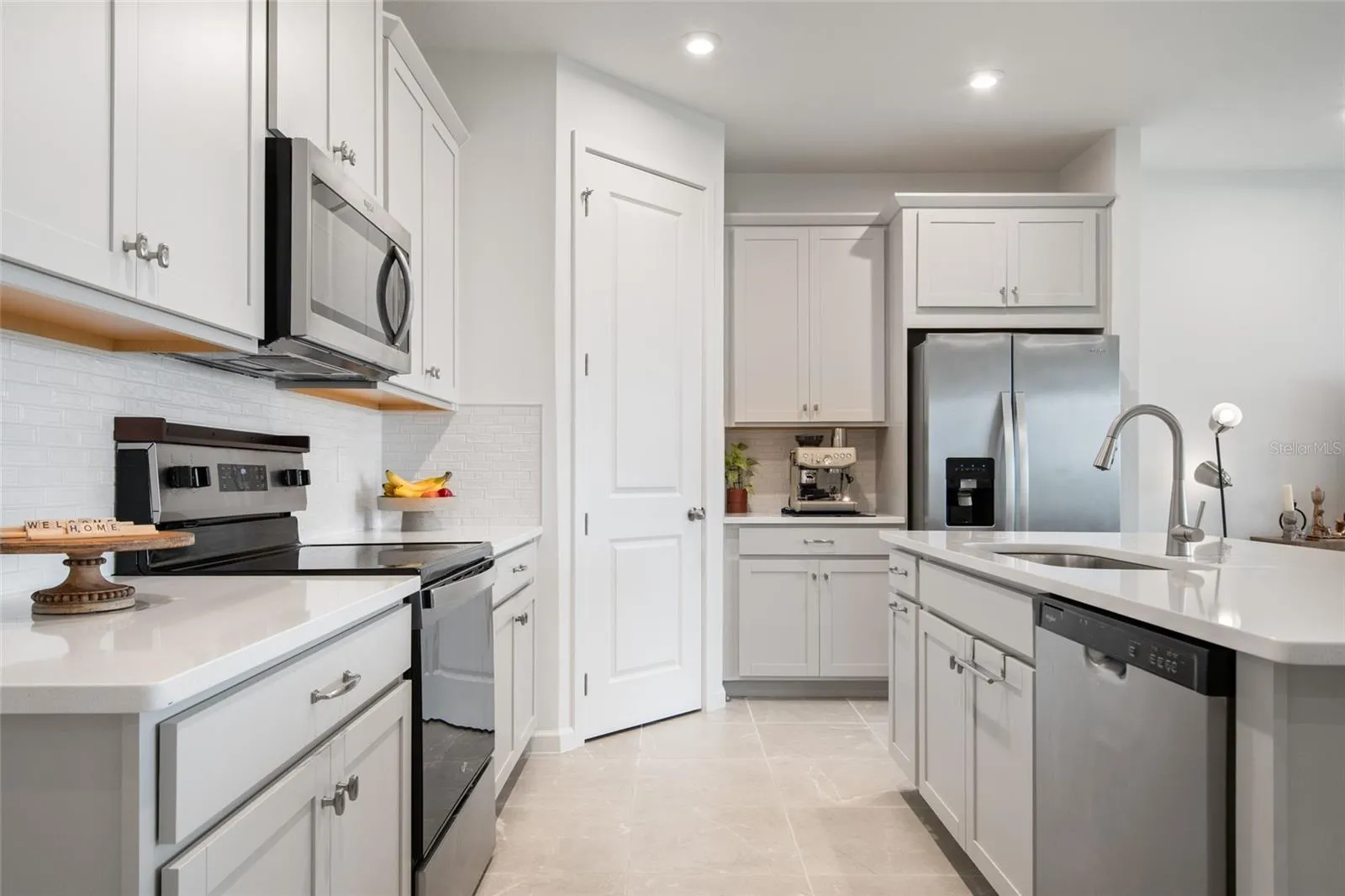transitional tile back splash, stainless steel appliances only 18 months old and plenty of prep space on the counters made of quartz.