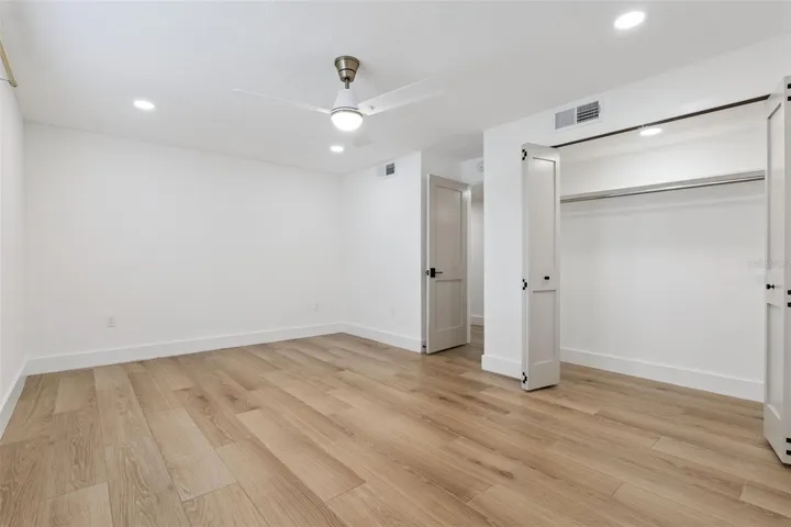 Bedroom with full wall closet, ceiling fan &amp; recessed lighting
