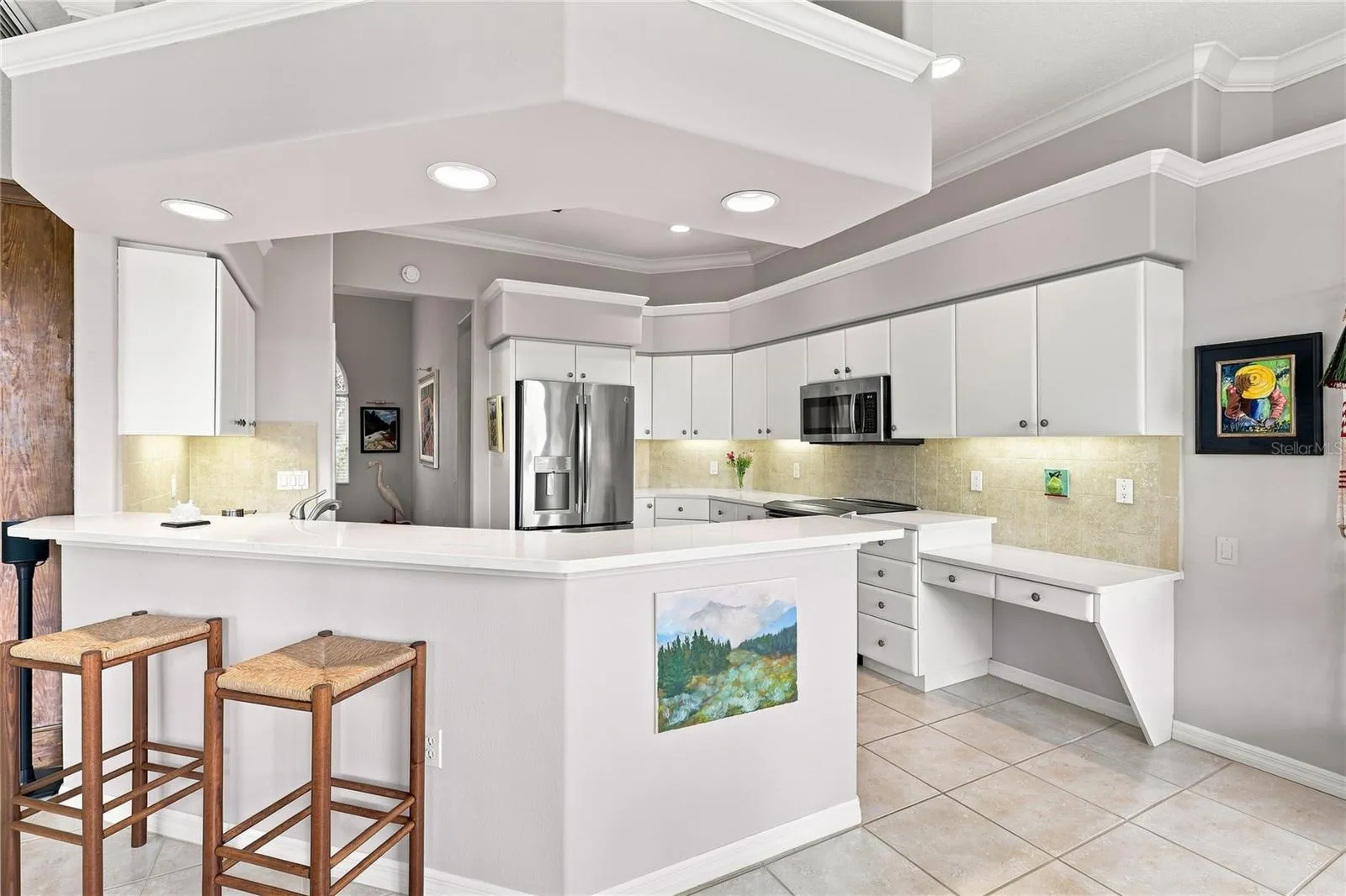 Bright kitchen with quartz countertops, abundant cabinetry and breakfast bar sesating