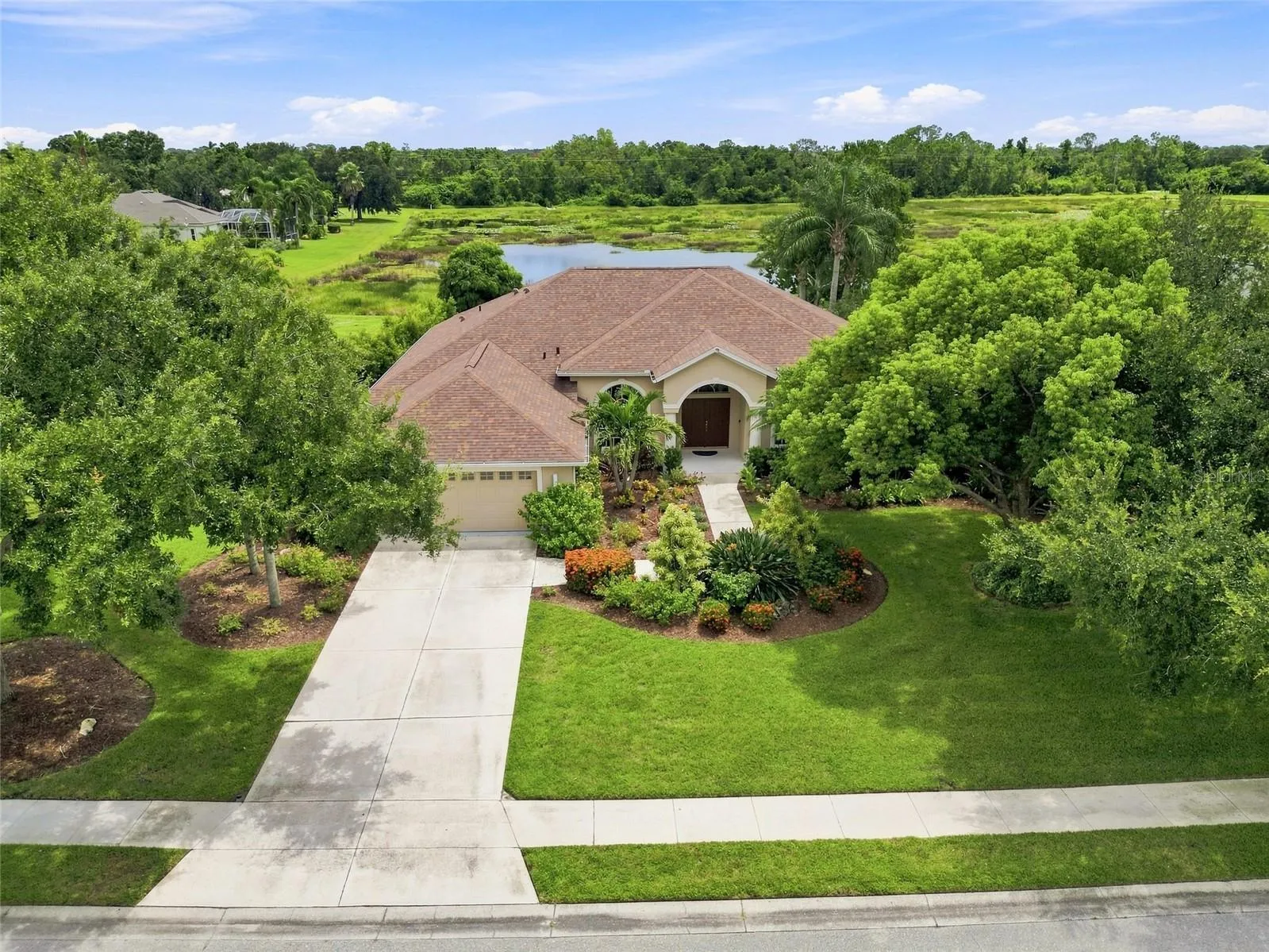 Beautifully landscaped home on a spacious, private lot with a serene natural backdrop