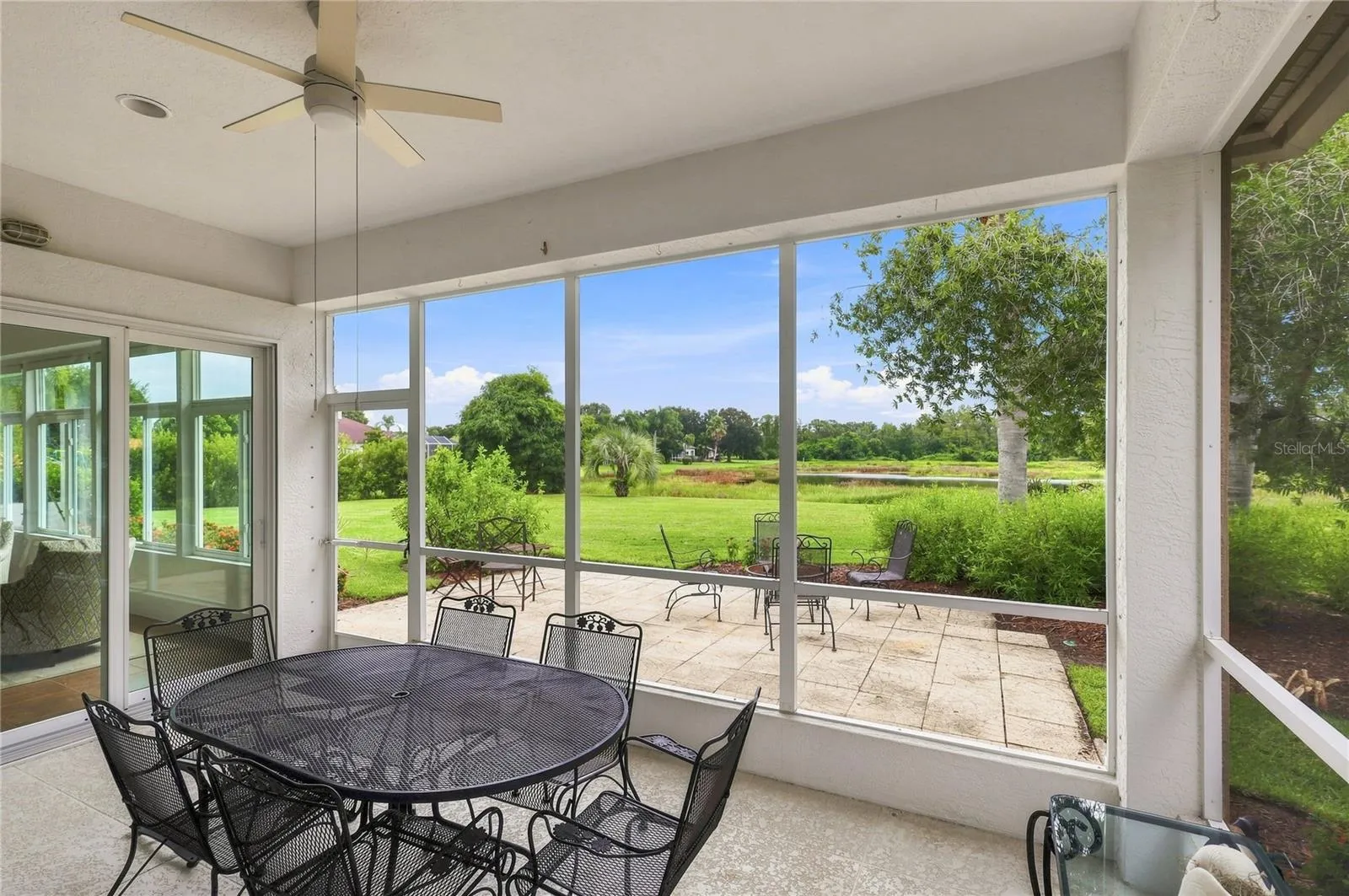Spacious screened lanai with hurricane screen protection overlooking the lush backyard and peaceful natural setting