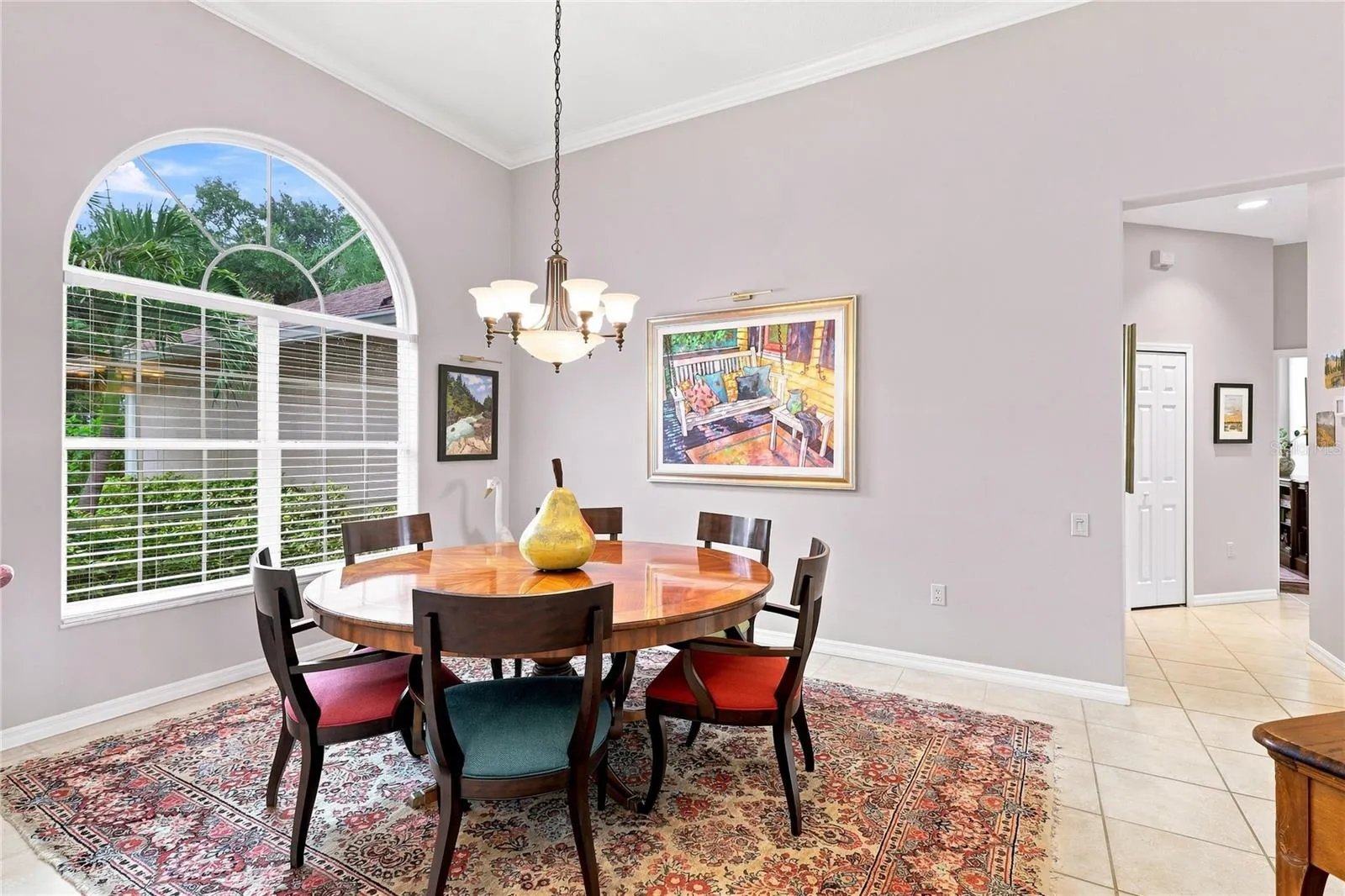 Formal dining room with high ceilings, crown molding and a large arched window