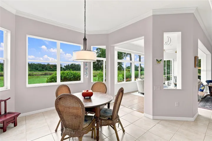 Bright breakfast area with expansive windows and peaceful back yard views