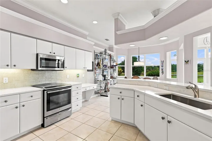 Updated quartz countertops, abundant cabinetry, plenty of workspace and an adjoining breakfast nook with peaceful backyard views