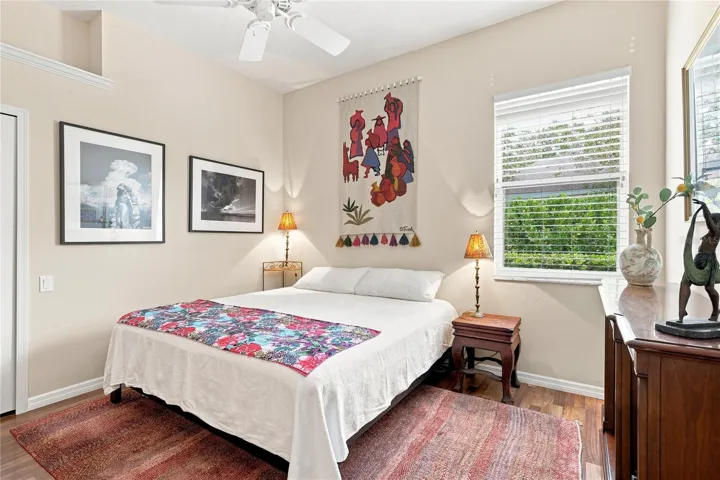 Bright guest bedroom with hardwood floors, high ceilings and generous natural light