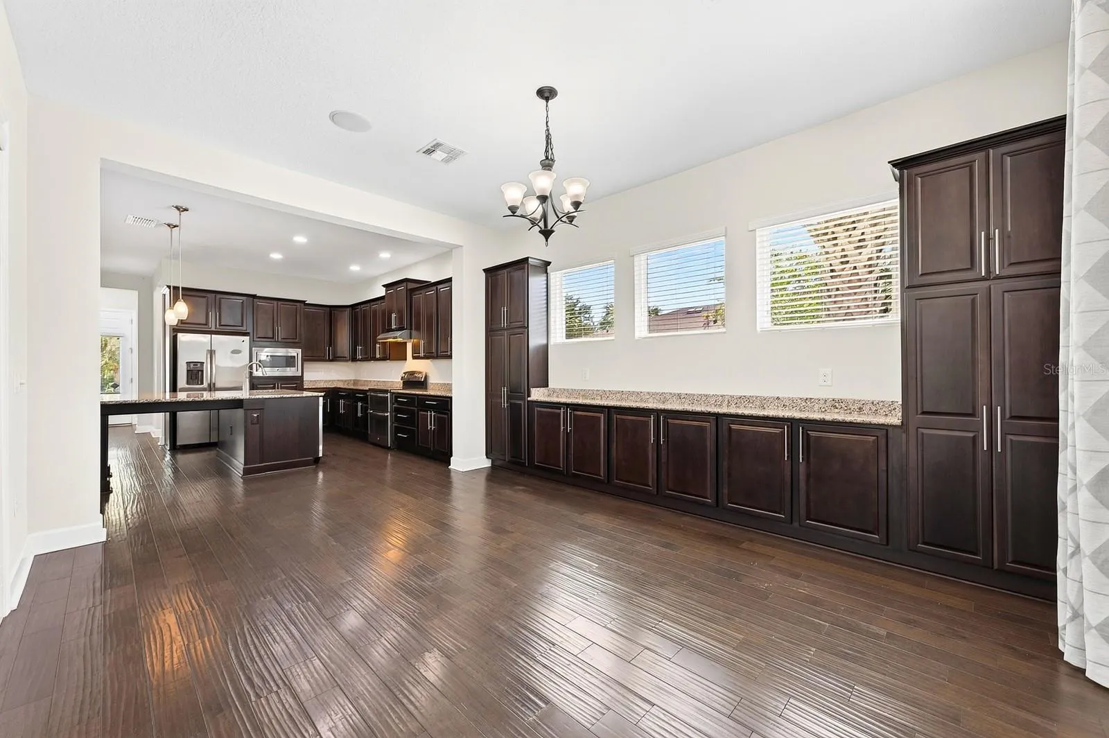 The rich cabinetry extends from the kitchen into the dining room for endless storage.