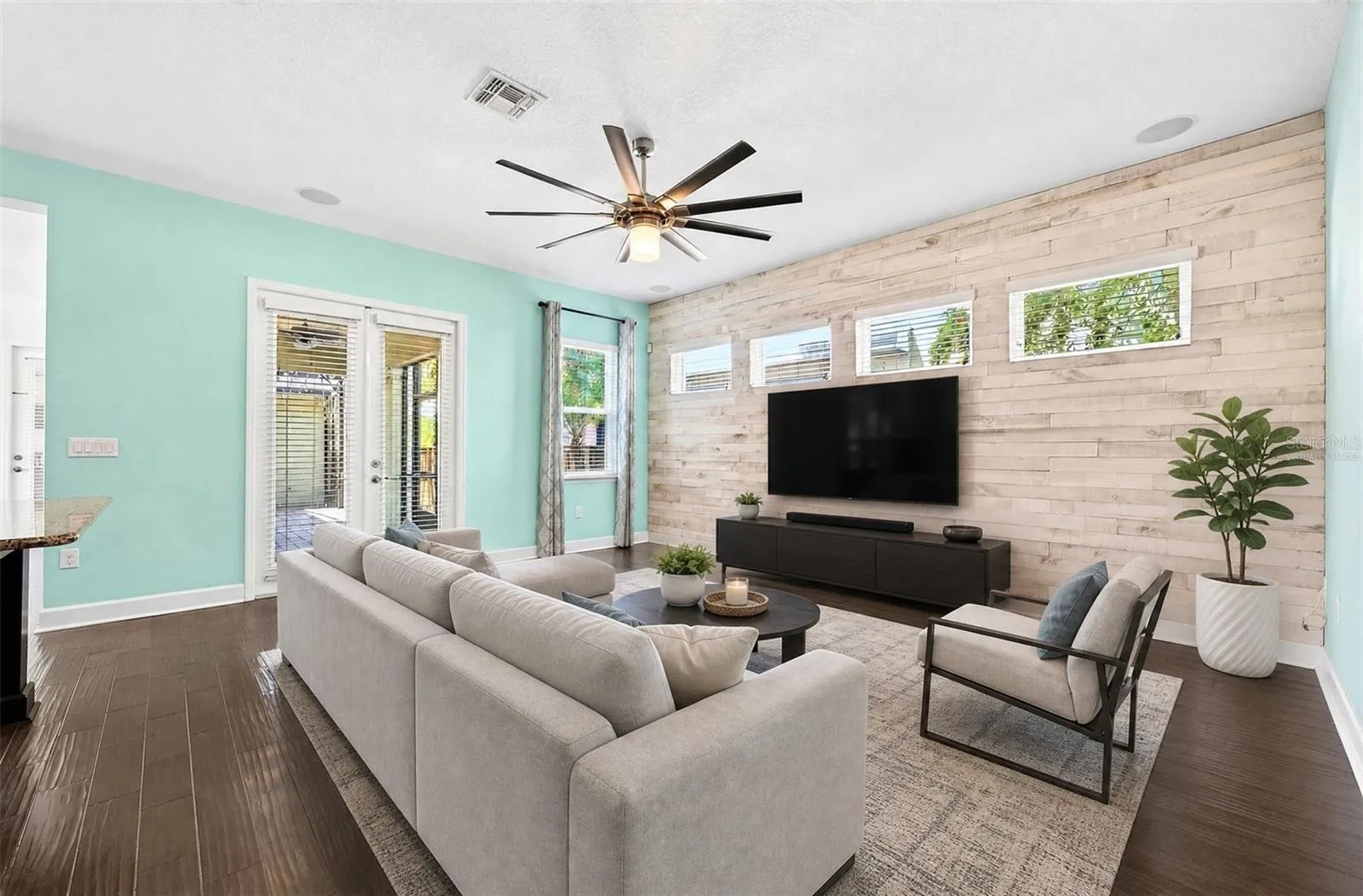 A custom accent wall adds personality to the living room. Virtually Staged.