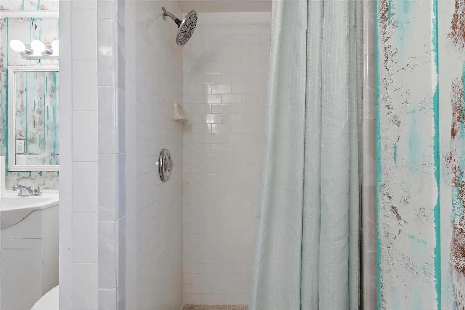 Walk-in shower detail with tiled surround.