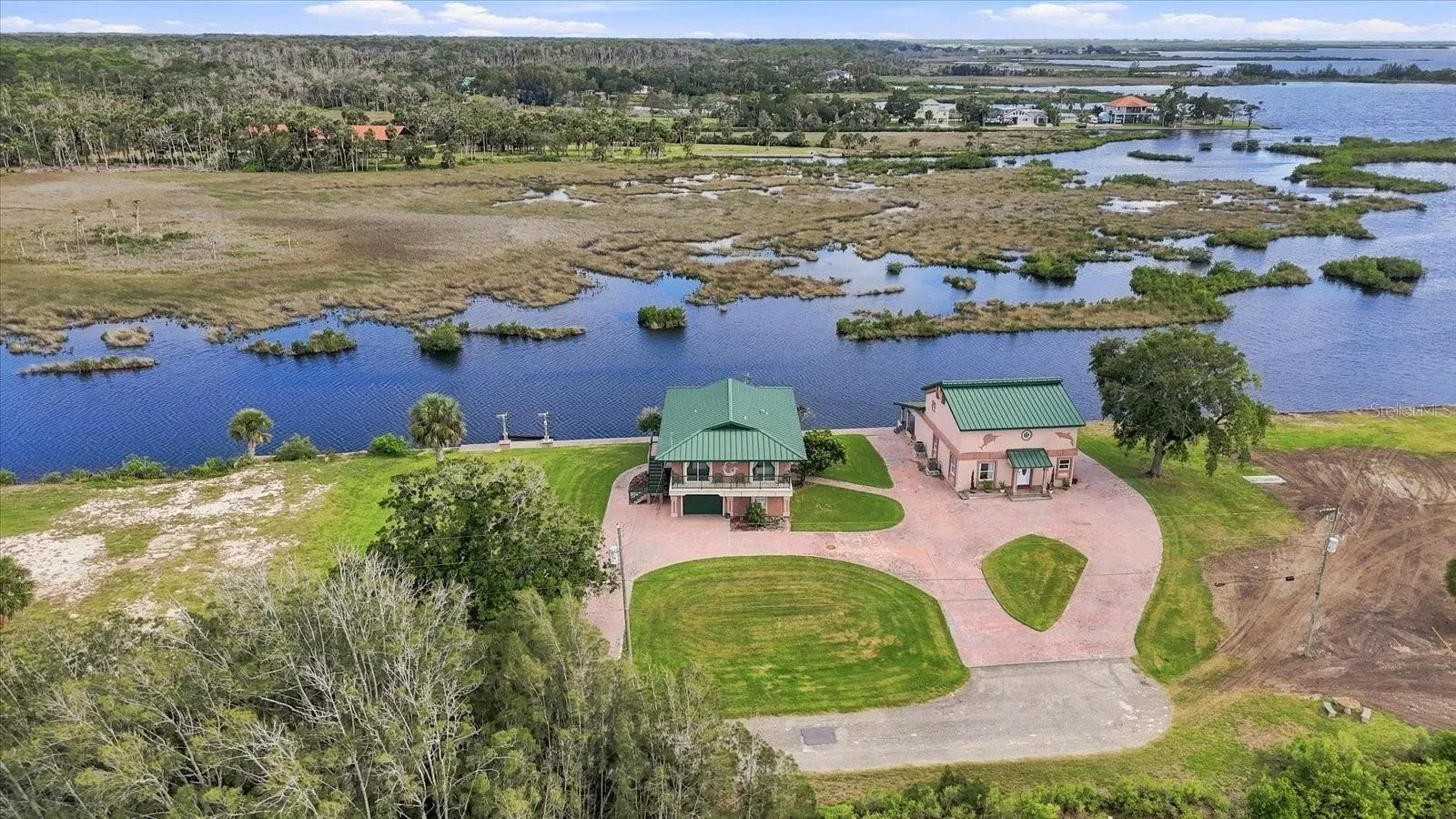 Expansive aerial showing the property surrounded by natural wetlands and waterways.