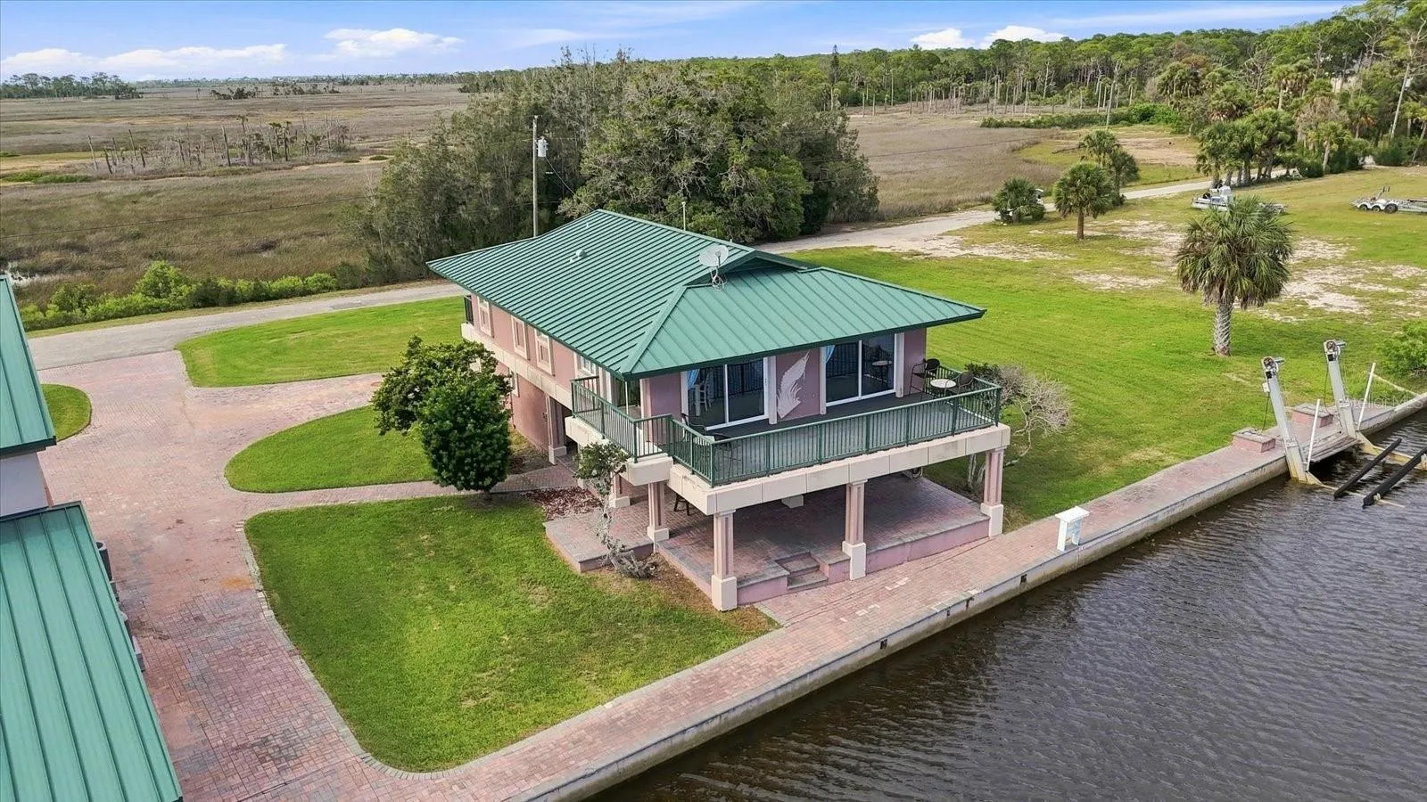 Aerial perspective highlighting the residence, seawall, lawn, and water frontage.