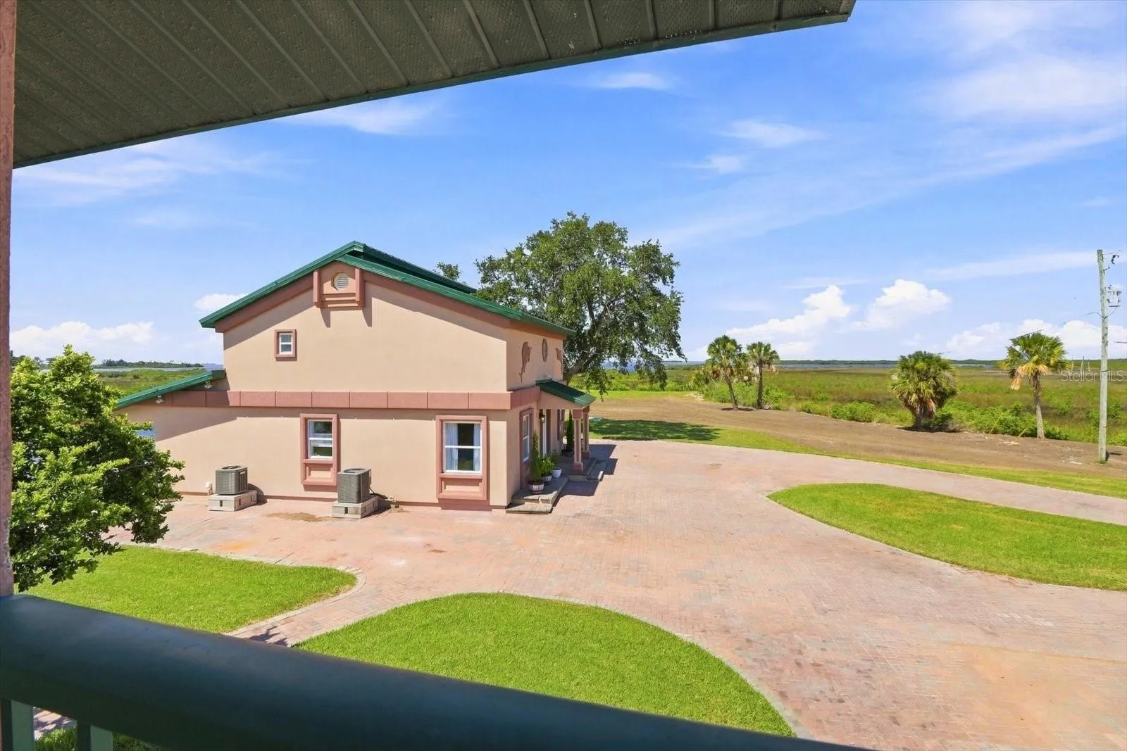 View across the grounds toward the detached building and surrounding coastal landscape.