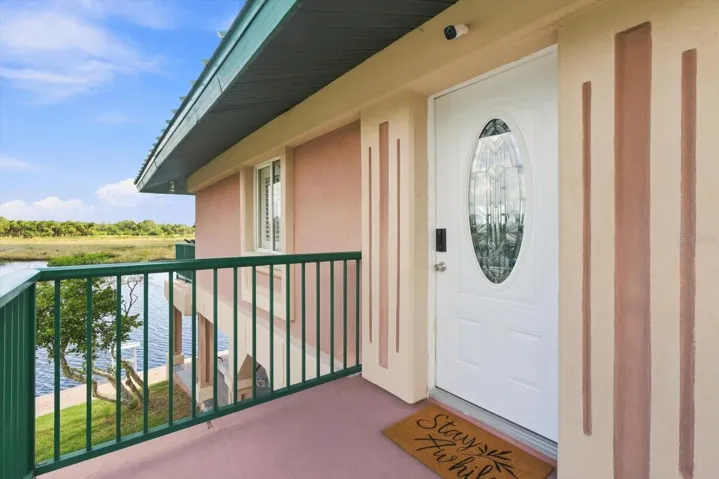 Upper-level entry landing with waterfront views nearby.