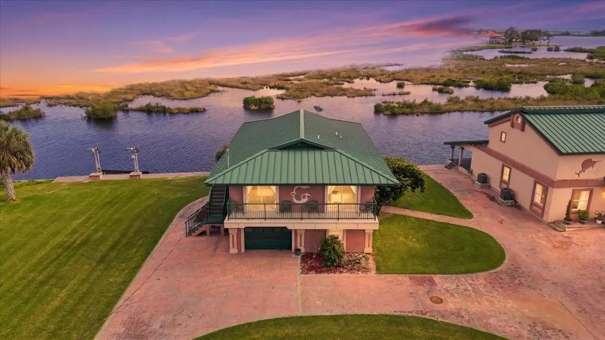 Twilight aerial showcasing the waterfront residence and natural coastal setting.