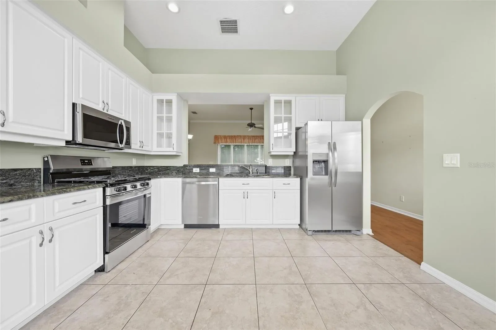 Spacious kitchen featuring granite countertops, stainless steel appliances, abundant cabinetry, and generous workspace.
