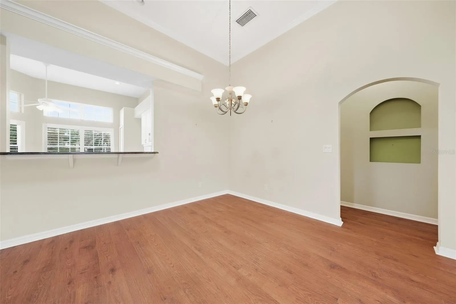 Spacious dining area with vaulted ceilings and warm wood flooring.