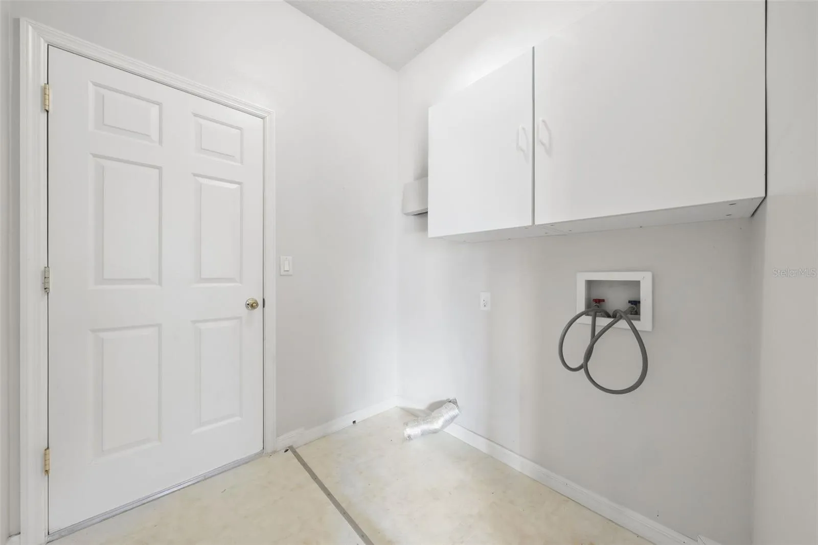 Convenient indoor laundry room with built-in storage cabinets.