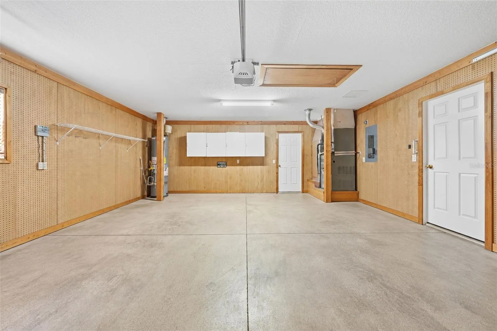 Spacious garage with built-in storage, workshop space, and convenient attic access!