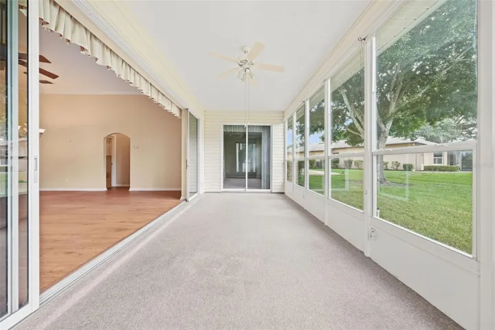 Spacious enclosed Florida room with walls of windows, abundant natural lights, and seamless access to the main living area.
